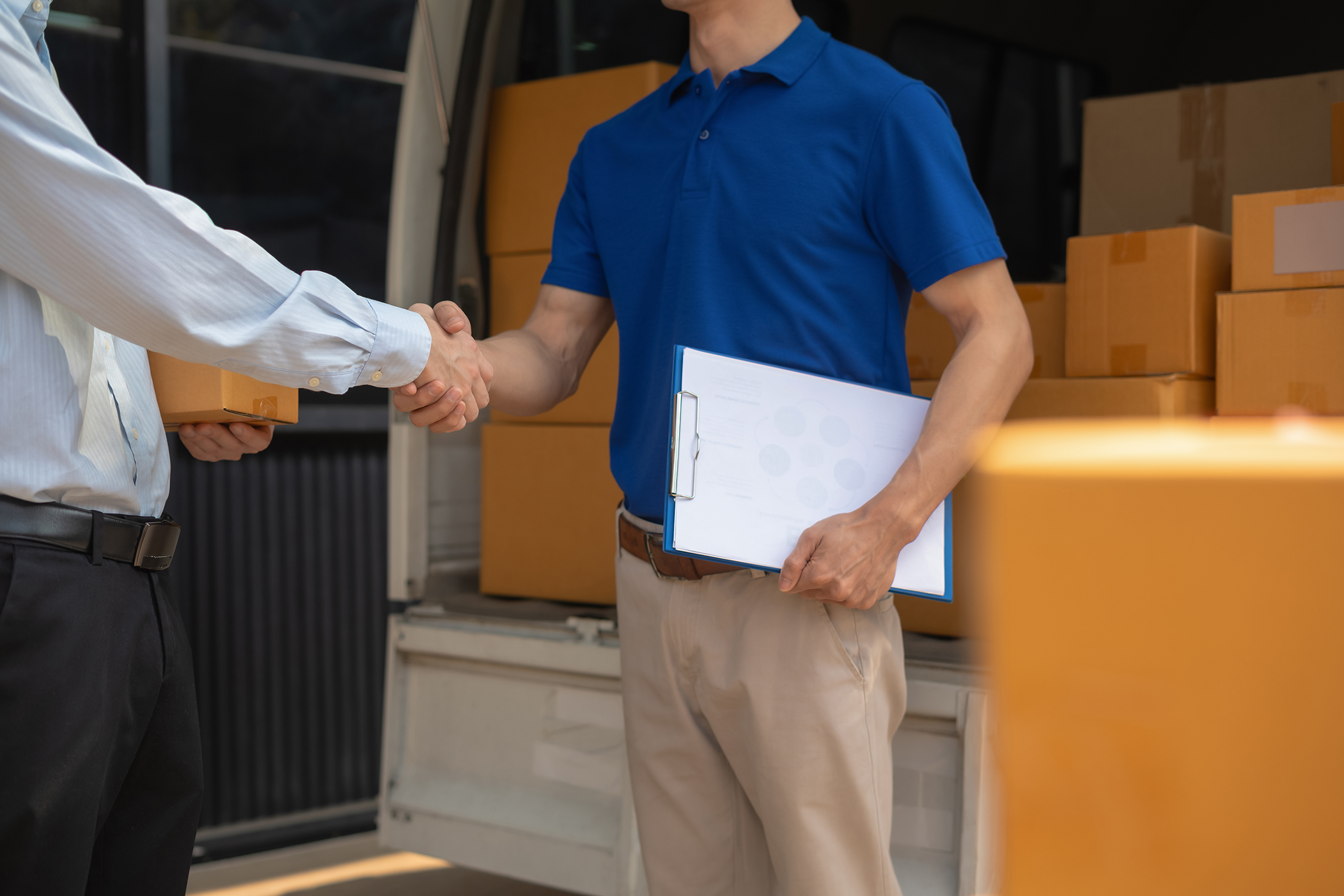 delivery-handshake-cargo-boxes-in-truck-day-2026-03-25-09-16-37-utc copia